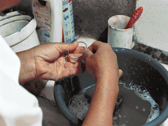 Mamie nettoie un bracelet dans une bassine.