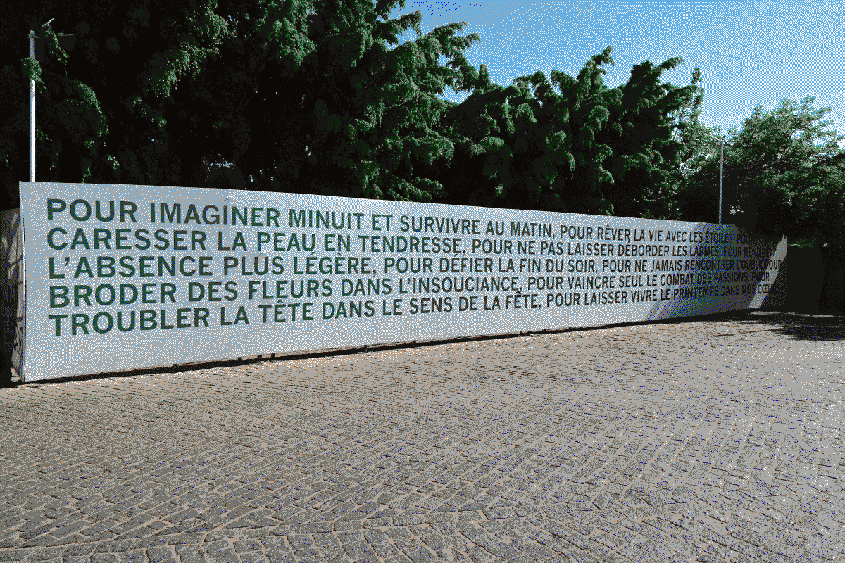 Photo d'un poème rédigé sur un mur à l'extérieur du centre: "Pour imaginer minuit et survivre au matin, Pour rêver la vie avec les étoiles, Pour caresser la peau en tendresse, Pour ne pas se laisser dérober les larmes, Pour rendre l'absence plus légère, Pour défier la fin du soir, Pour ne jamais rencontrer l'oubli, Pour broder des fleurs dans l'insouciance, Pour vaincre seul le combat des passions, Pour troubler la tête dans le sens de la fête, Pour laisser vivre le printemps dans nos coeurs."