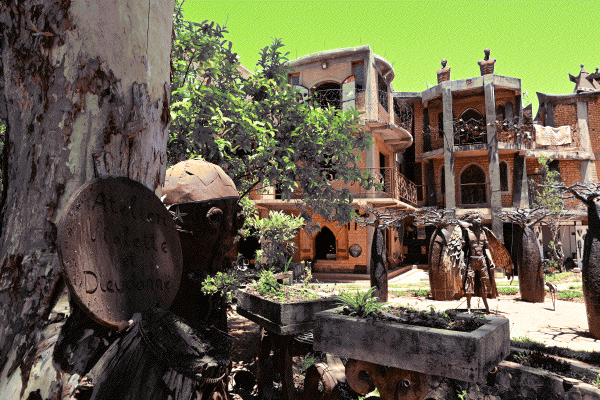 Photo du batiment principal de l'atelier, dans lequel sont installées les boutiques, on peut voir des statues en métal installées dans les espaces extérieurs