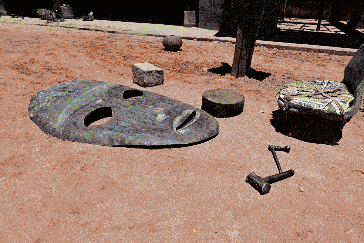 Photo d'un masque en cours de fabrication à côté d'un poste de trvail près duquel reposent les outils