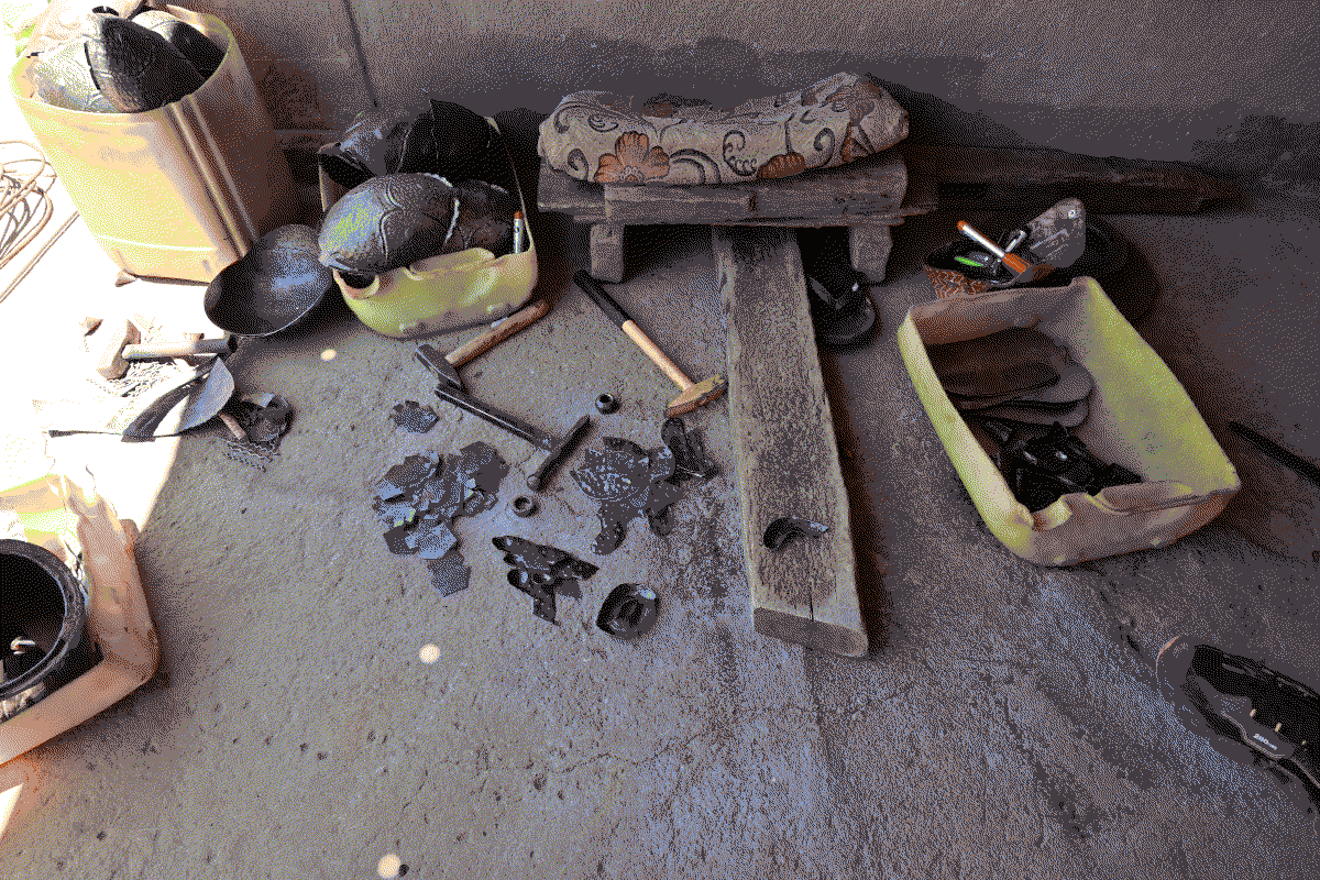 Photo d'un poste de travail auprès duquel on peut voir les outils et les morceaux d'oeuvres finis autour du poste de travail